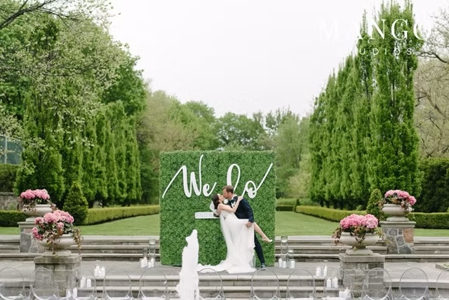 A garden ceremony with a green floral wall at Graydon Hall Manor
