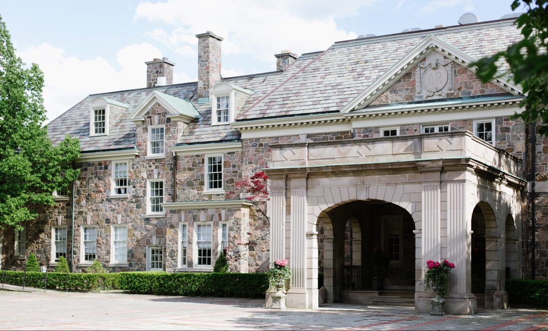 Graydon Hall Manor’s stone façade and arched entrance framed by trees