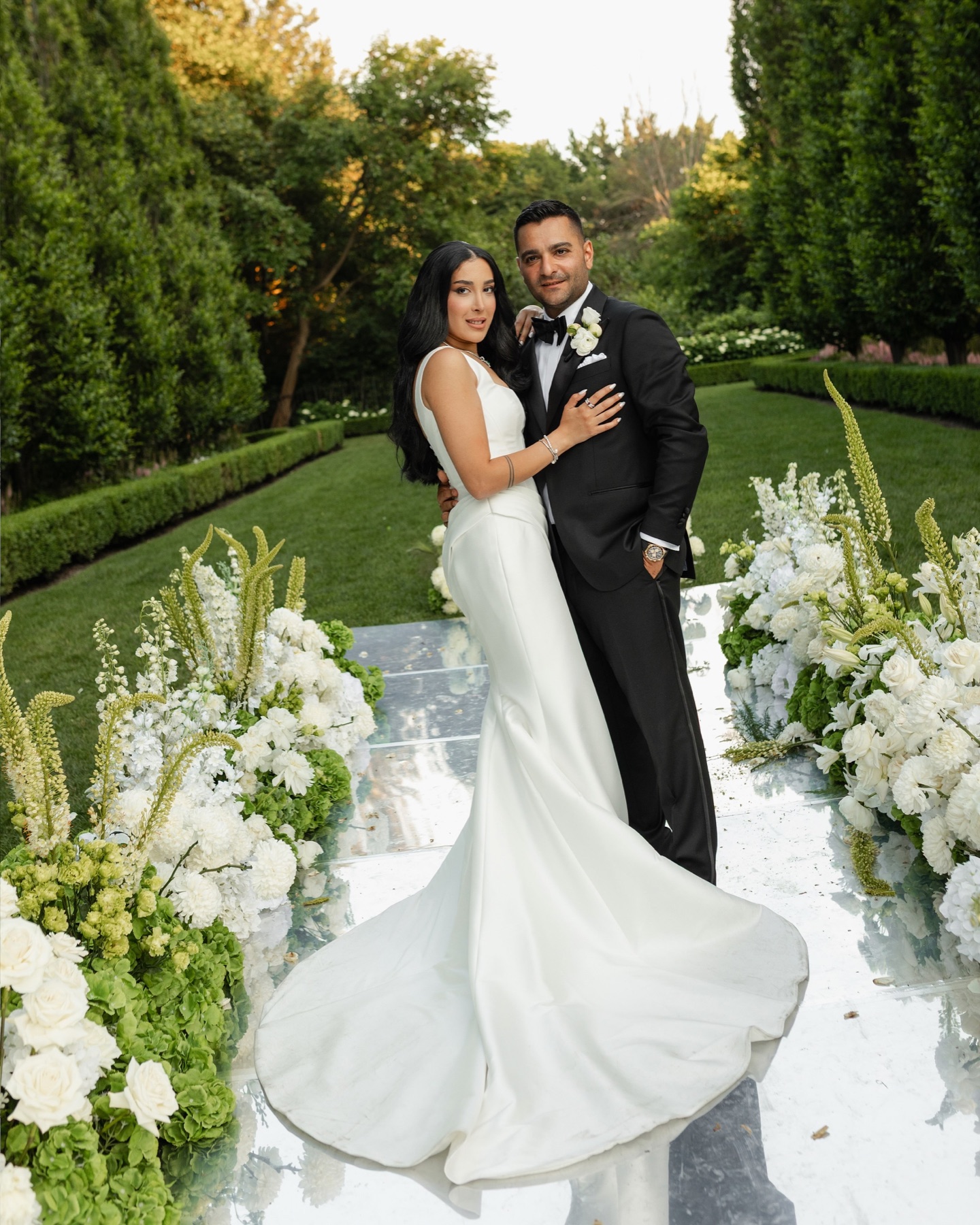 A bride and groom framed by abundant garden ceremony florals