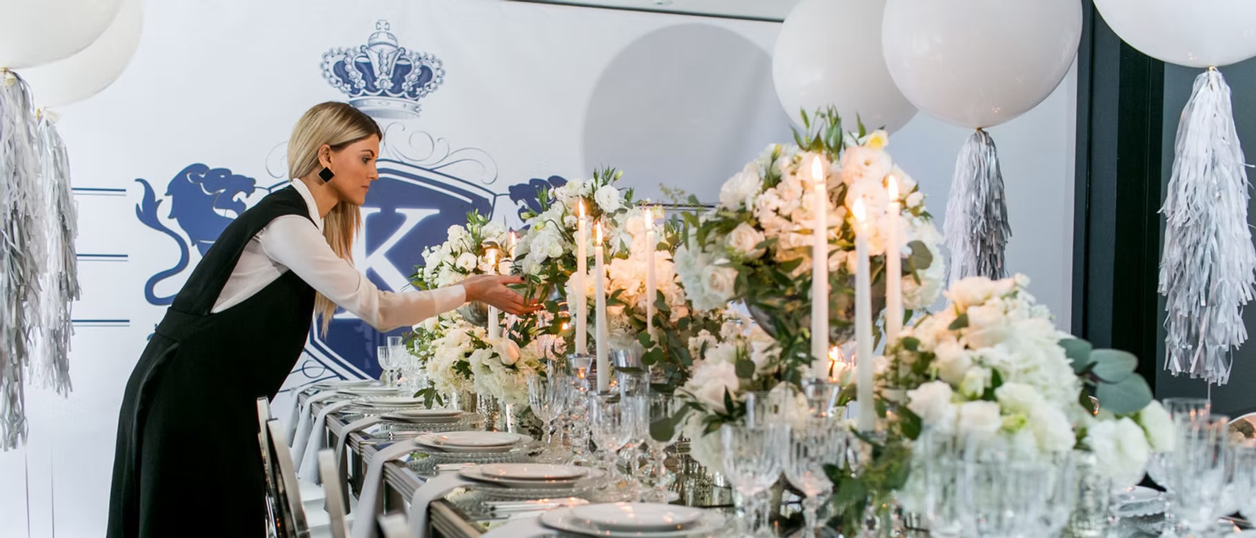 A Lux Events Co team member styling a long floral table