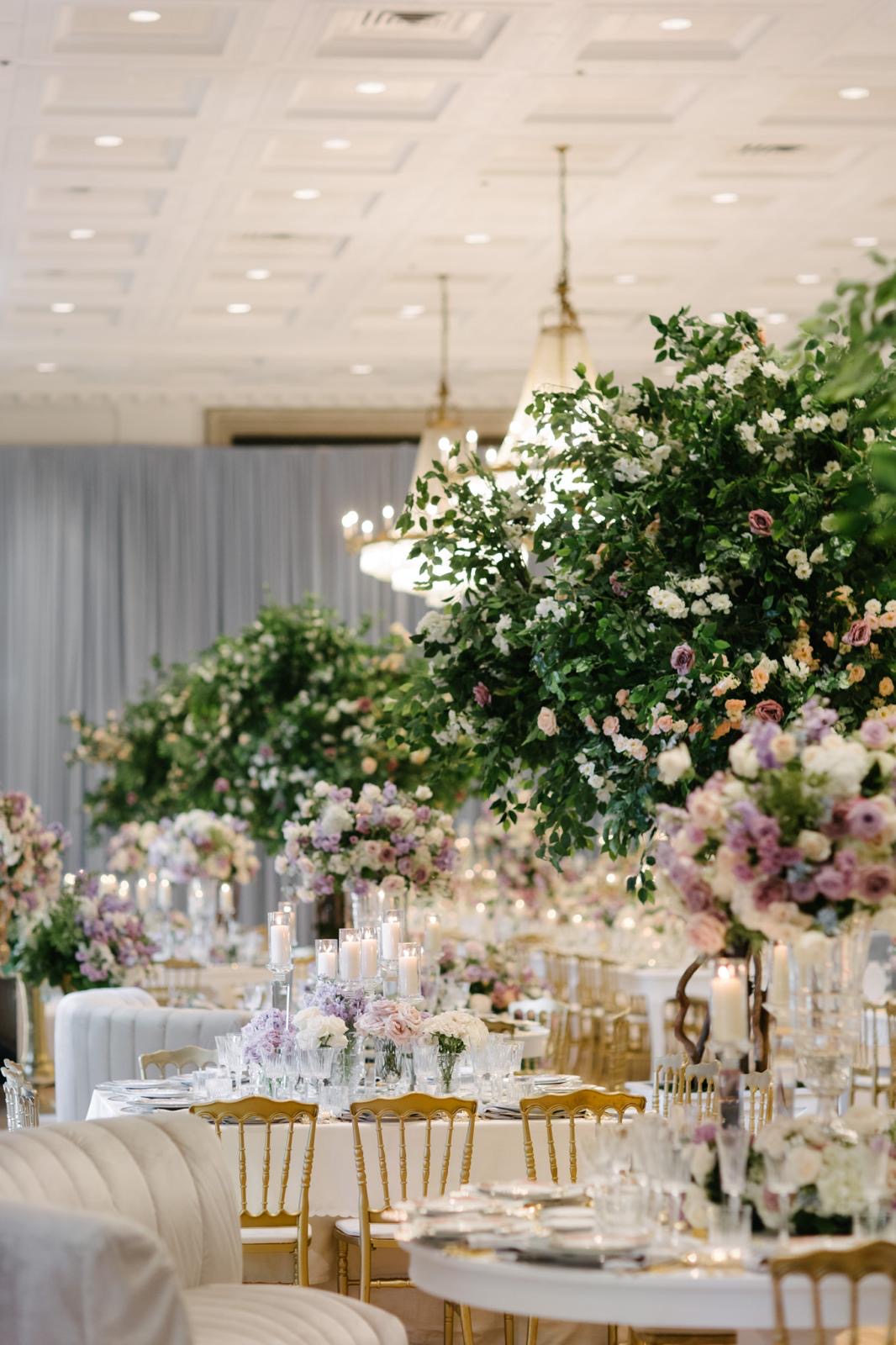 Flowering trees and lavender arrangements beneath the Fairmont ballroom chandeliers