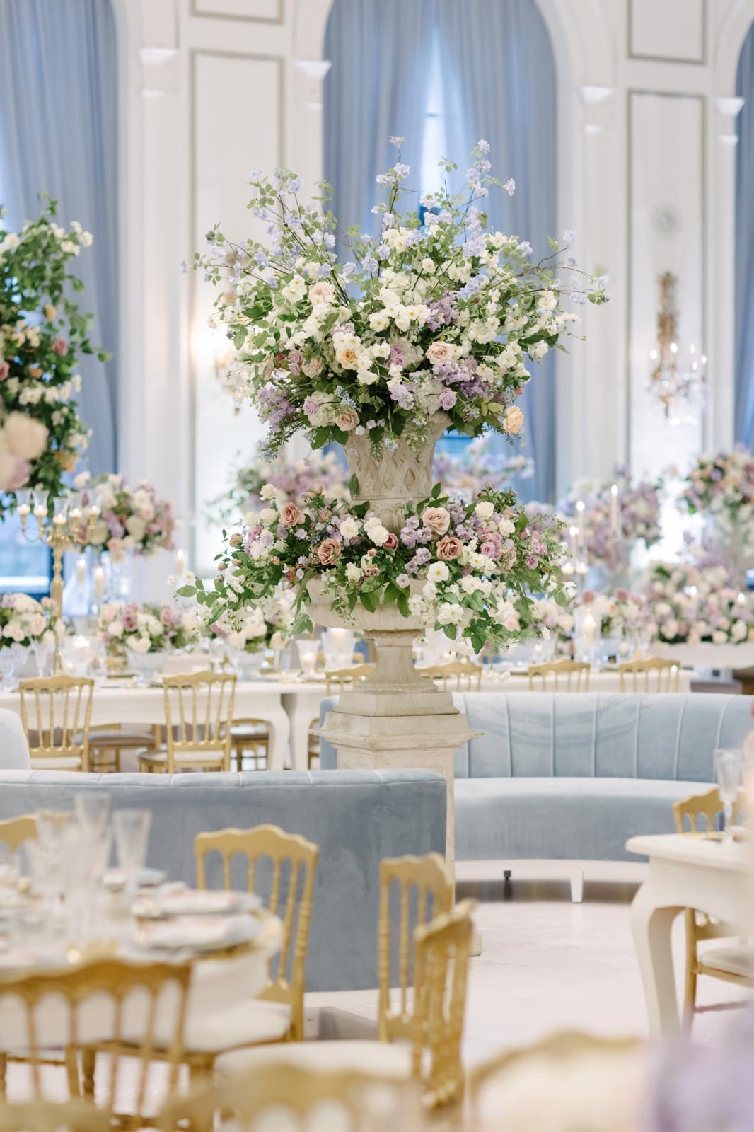 A sculptural lavender and ivory floral urn beside powder-blue lounge seating