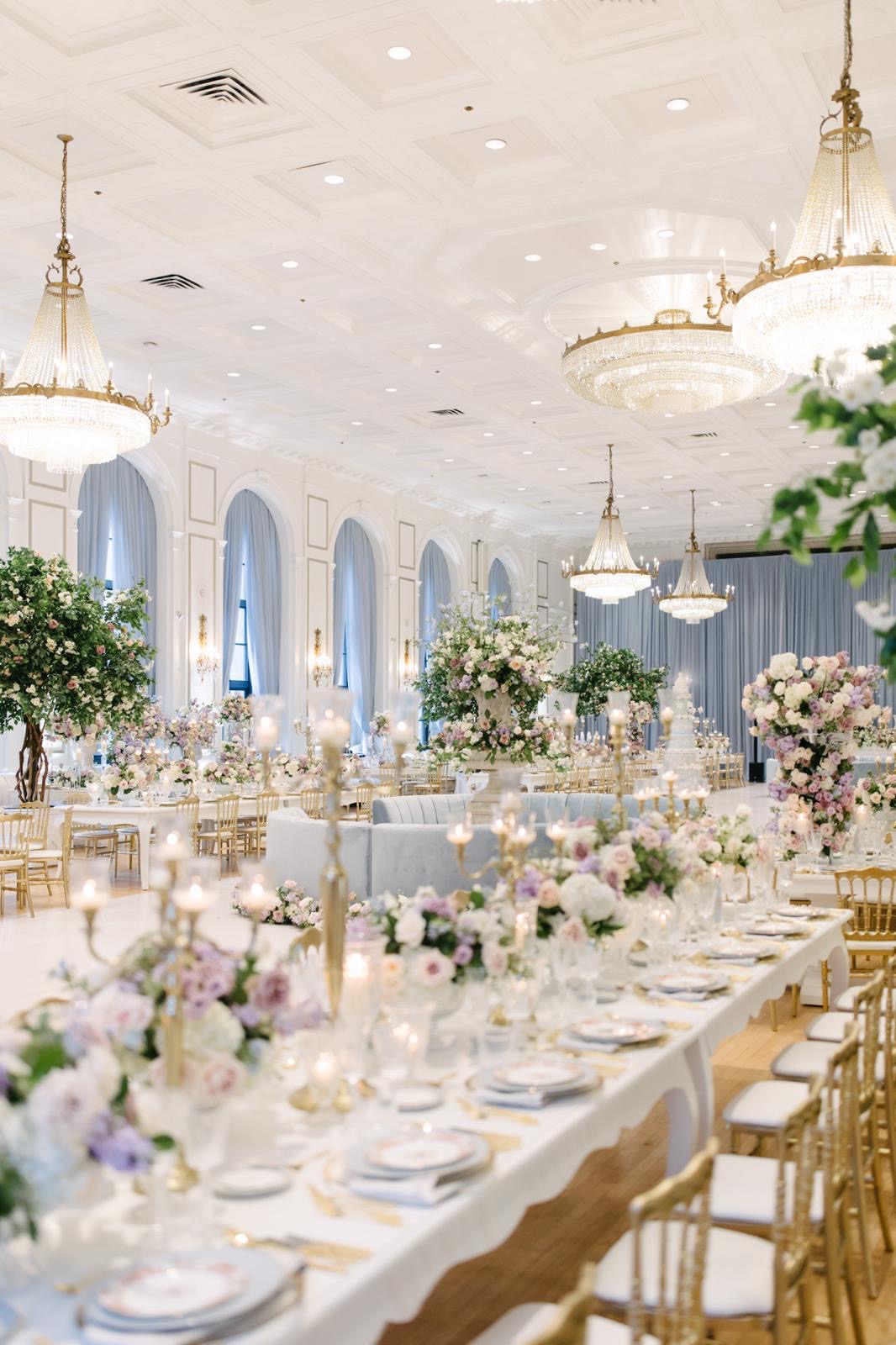 Lavender and blush wedding flowers, flowering trees and pale-blue accents beneath crystal chandeliers at Fairmont Royal York