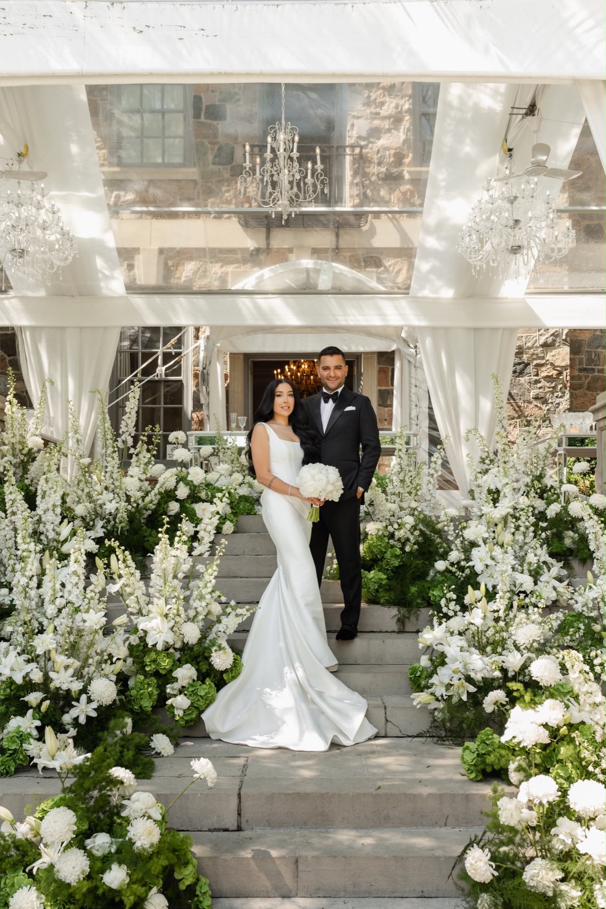 A couple standing on flower-lined steps at Graydon Hall Manor