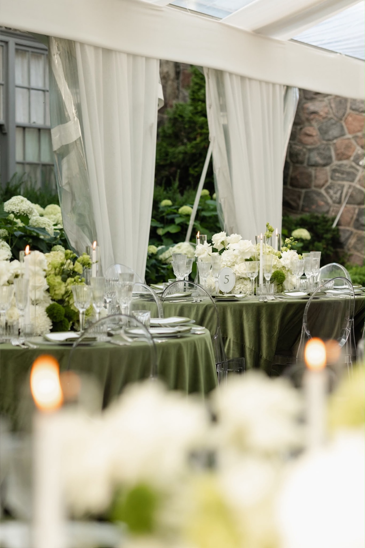 Olive green reception tables framed by candles and white flowers