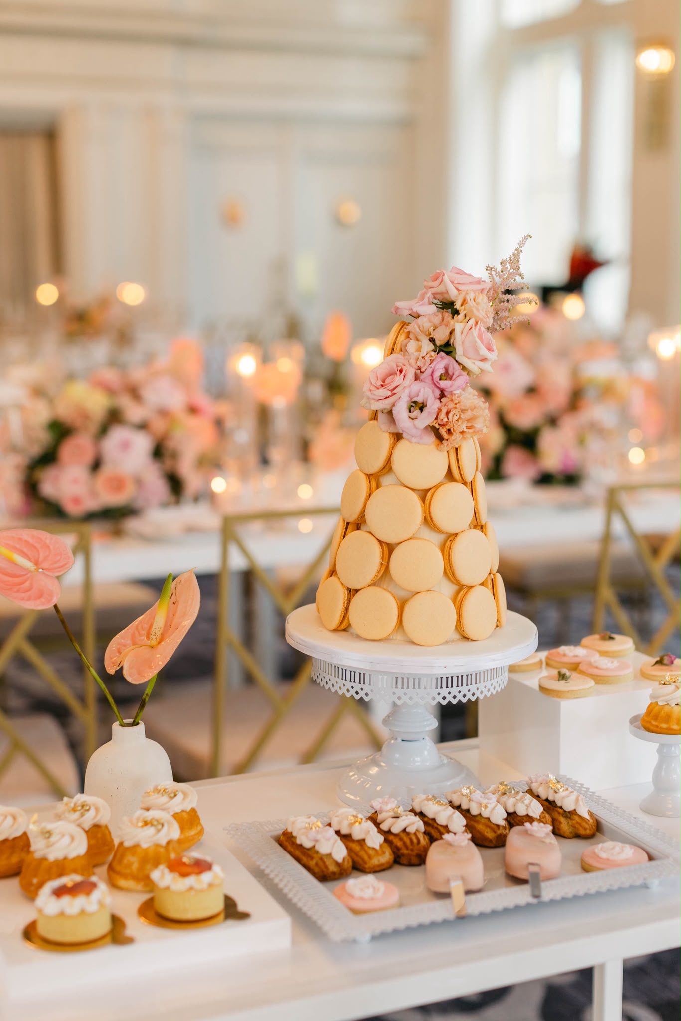 A macaron tower and petite desserts framed by peach flowers
