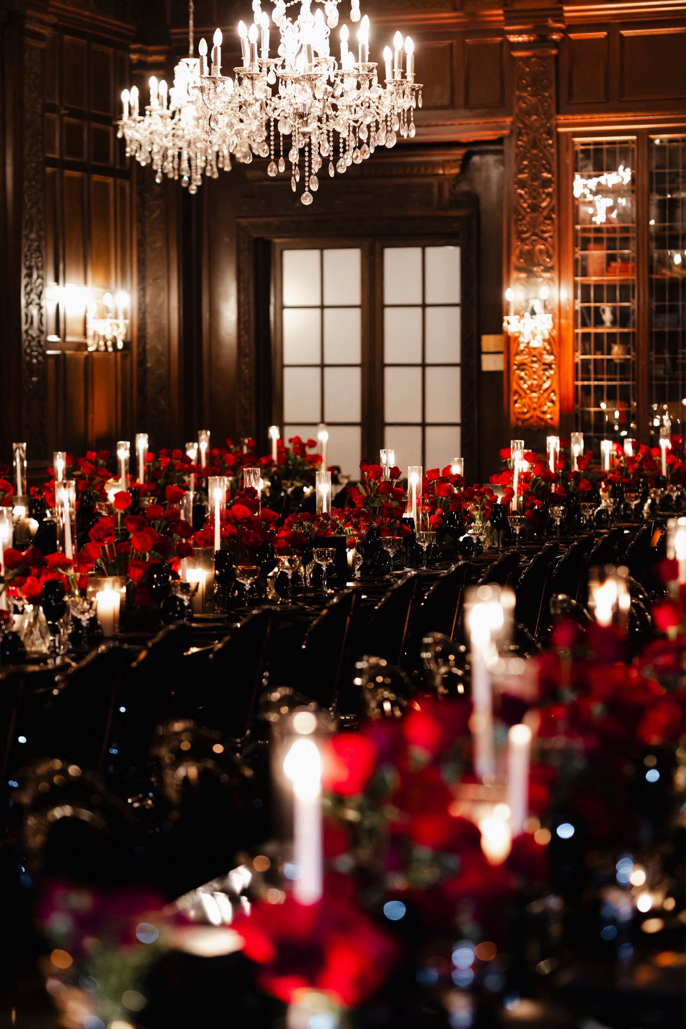 Long black tables filled with red roses beneath Casa Loma's crystal chandeliers