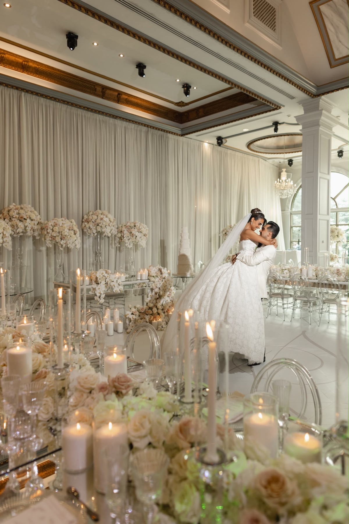 A couple dancing in a blush and white candlelit reception